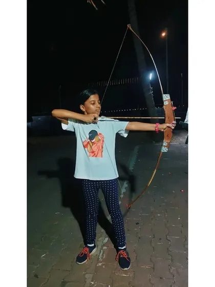 This young archer is building her skills one arrow at a time during an evening session.