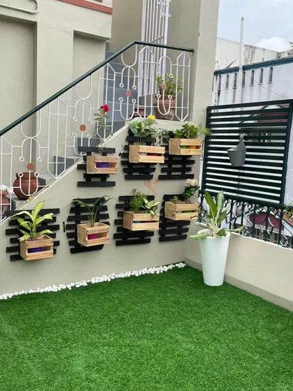 We maximize urban living spaces with custom terrace and balcony solutions. This setup features durable artificial turf, a space-saving vertical wall planter, and stylish pots.