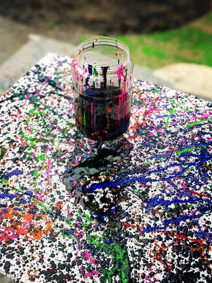 A table splattered with paint after a wonderfully messy and creative workshop. This is the beautiful aftermath of collective joy.