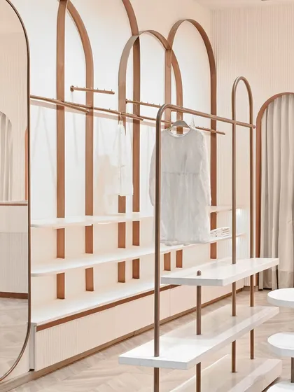 For the kids' boutique Kate & Oscar, we designed these custom clothing racks with rose gold arches and white shelves. The design is light, whimsical, and highly functional.