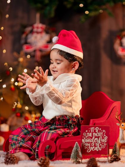 A playful moment from a Christmas mini session, with a toddler in a Santa hat enjoying the festive atmosphere.