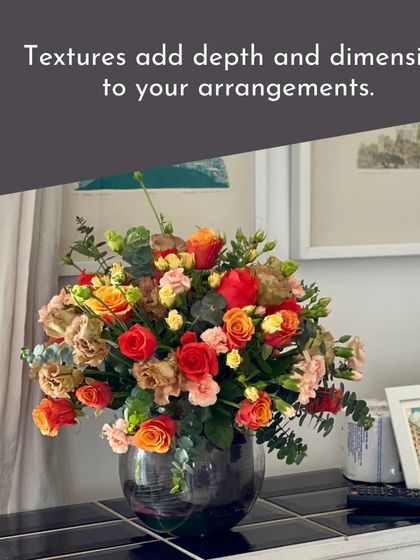 This beautiful home arrangement shows how texture adds depth and dimension. The mix of colors and flower types creates a rich, inviting feel.