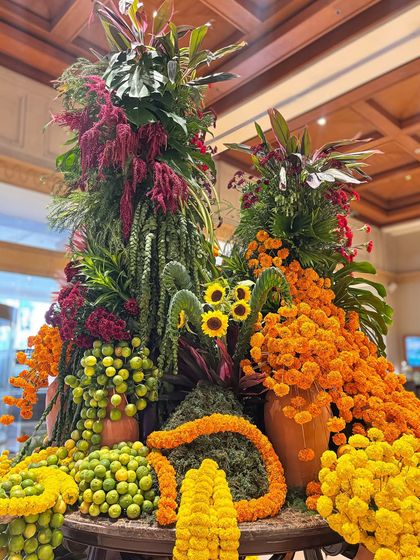 This angle captures the artistic arrangement of the flowers, including sunflowers peeking through the marigolds and greenery. Every detail is thoughtfully placed to create a stunning visual impact from all sides.