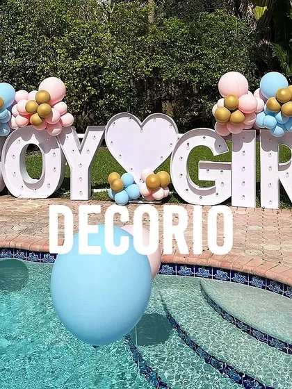I can create large-scale, impactful decorations for any space, like this poolside gender reveal. The large light-up "BOY GIRL" marquee letters make a bold statement, framed by pink and blue balloon clusters for the big announcement.
