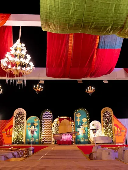 The expansive and colorful stage for the Radha-Krishna themed sangeet, showcasing our ability to transform large spaces with creative backdrops, drapery, and lighting.