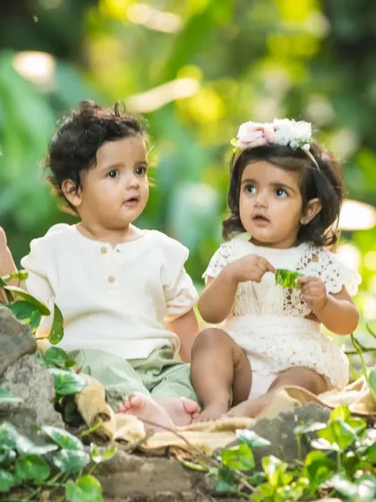 Curious about the world together. These twins explore nature side-by-side in this candid outdoor shot.
