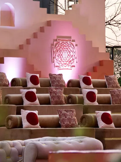 Amphitheater-style seating for the Shri Yantra ceremony, ensuring every guest has a perfect view. The custom cushions and illuminated decor piece continue the theme throughout the space.