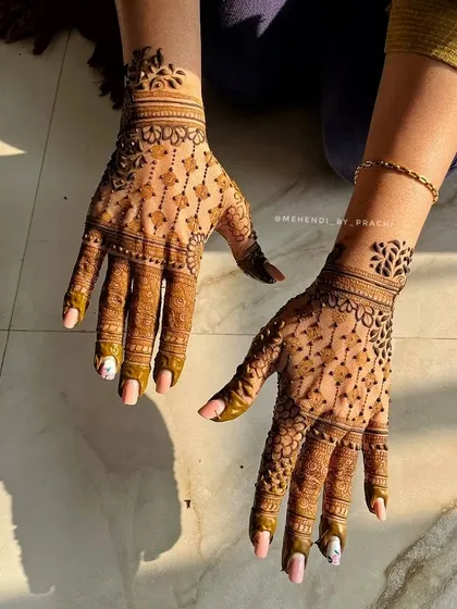 This delicate back-hand design uses fine lines and dot work to create a lace-like effect. The small floral motifs on the wrist add a touch of classic elegance.