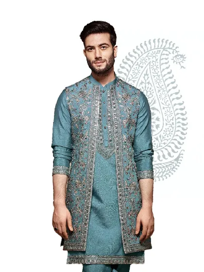 This teal blue kurta is paired with a heavily embroidered open-front jacket. The silver and pink threadwork creates a stunning visual, perfect for a grand sangeet or reception.