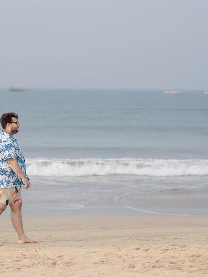 A wide shot of the couple walking towards each other on the beach, creating a sense of anticipation and romance.