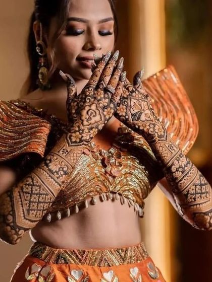 A beautiful, candid shot of a bride admiring her full-arm bridal mehndi.