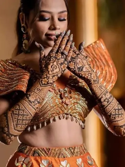 A beautiful, candid shot of a bride admiring her full-arm bridal mehndi.