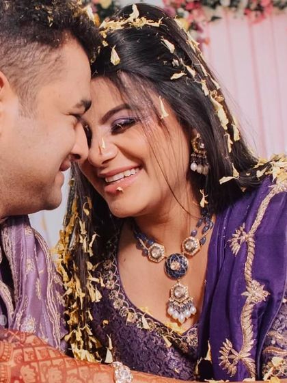 A beautiful, candid moment from the Haldi ceremony, with the couple sharing a laugh as they are showered with flower petals.