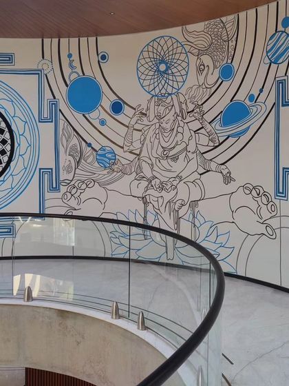 A detail of the 'creator' section of the atrium mural, featuring intricate mandala patterns and celestial bodies.