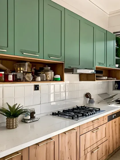 We combined sage green upper cabinets with natural wood lower cabinets for a fresh, contemporary look. The open shelf provides easy access to frequently used spices, blending practicality with modern kitchen aesthetics.