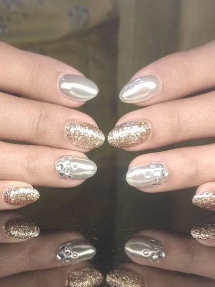 A glamorous mix of metallic silver, gold glitter, and silver rhinestone accent nails.