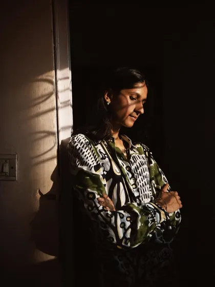 A friend leaning against a doorway, with beautiful shadows falling across her. This is a perfect example of how natural light can paint a portrait.