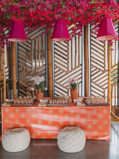 A vibrant food station at a pre-wedding party. We used a bamboo structure εταιρείας, bright pink bougainvillea, and colorful lampshades to create a fun and festive corner for guests to enjoy some treats.