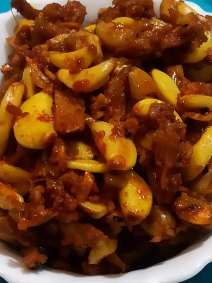 A close-up of my Ginger Garlic Pickle, showing the texture of the ginger and garlic cloves coated in rich, dark masala.