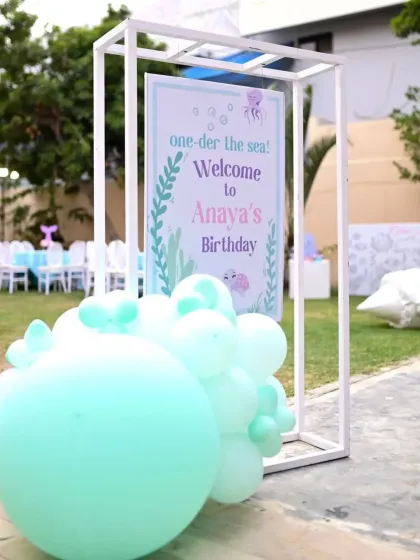 A personalized 'one-der the sea' welcome sign greets guests, setting the tone for the magical underwater adventure.