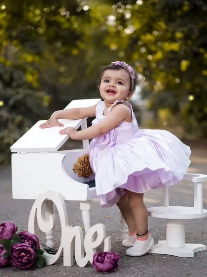 A princess in lavender. This little girl is enjoying her outdoor birthday shoot with our mini white piano prop. The natural light makes the photo so soft and beautiful.