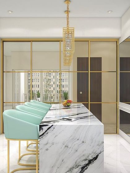 A kitchen designed for entertaining, with a large marble island that doubles as a breakfast bar. The glass partition behind it can separate the kitchen from the dining area when needed.