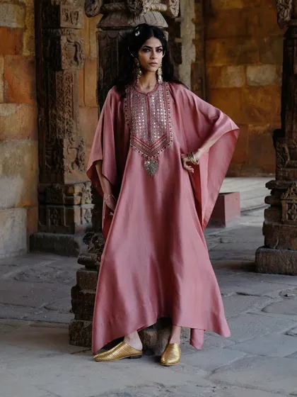 The kaftan is a silhouette I adore for its effortless grace. This flowing pink kaftan, captured against a historic backdrop, showcases how comfort and high fashion can coexist beautifully, perfect for a destination wedding or a festive brunch.