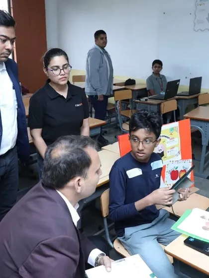 A student explains his project to our founder and other guests during an event. We provide opportunities for students to present their work, building their confidence and communication skills.