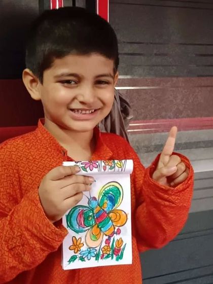 Ankush, a 6-year-old student, is happy with his colorful butterfly drawing. He used oil pastels to create a bright and cheerful insect with patterned wings.