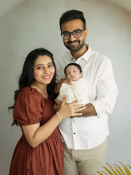 A classic family portrait where the new parents smile warmly at the camera. It’s a beautiful, happy memory of their first days as a family of three.