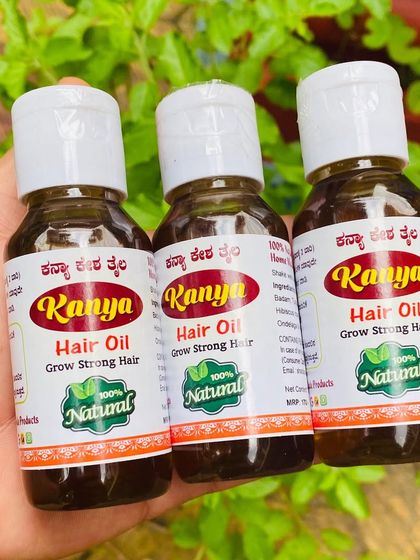 Another look at three bottles of my Kanya Hair Oil, with the natural Tulsi plant in the background.