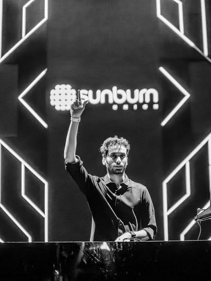 A classic black and white shot, raising a hand to the crowd at Sunburn Union.