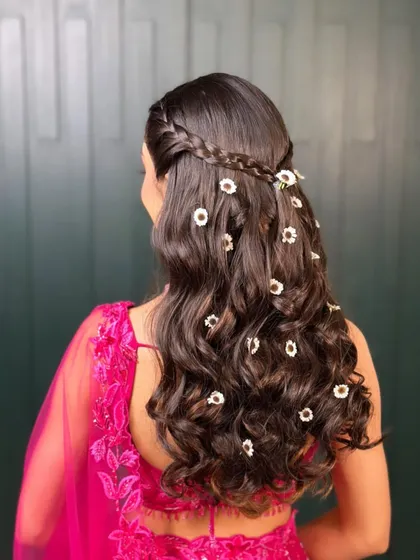 Full of blooms for a perfect mehendi hairstyle. I created soft curls and scattered delicate floral accessories throughout for a whimsical and romantic look.