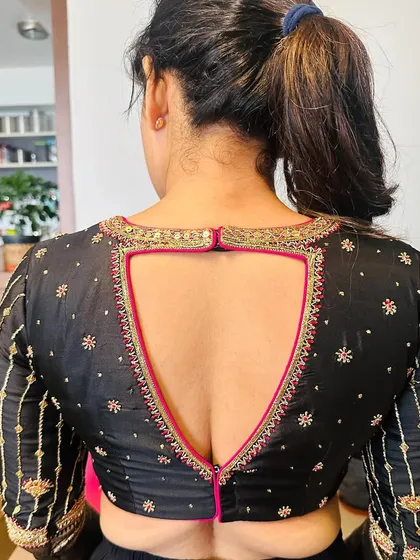 The gorgeous Amulya in a custom hand-embroidered black blouse. The deep V-cut back with pink piping adds a pop of color and modern style.