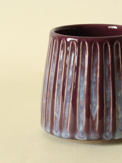 A close-up view of the Aubergine Drip mug, highlighting the way the glaze pools in the carved textures. It’s a piece that invites you to look closer and appreciate the details.