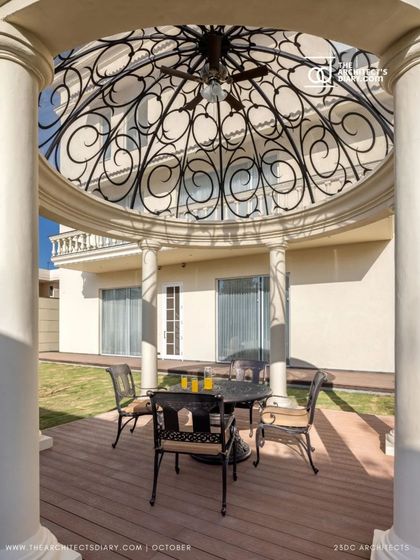 An outdoor gazebo at The Ivory Royale, featuring an ornate, domed ironwork ceiling. This shaded seating area provides a perfect spot to enjoy the landscaped gardens, blending classical design with outdoor comfort.