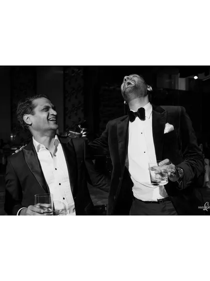 Shivam shares a laugh with a friend at his party. These candid moments of friendship and joy are an essential part of the wedding story.