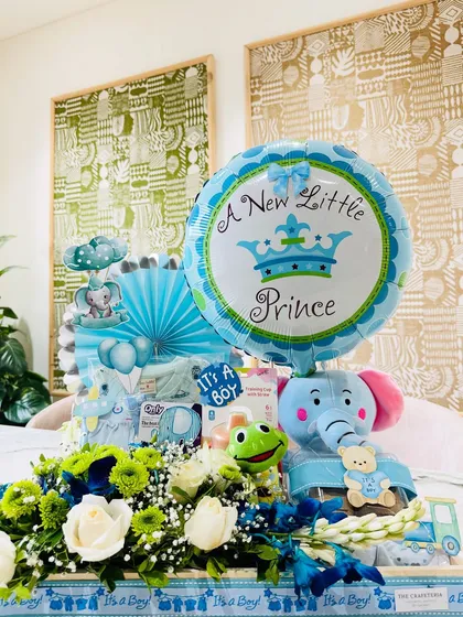 A royal welcome for the little prince! This hamper features a blue elephant plush, a 'It's a Boy' balloon, and a curated selection of gifts for the newborn.