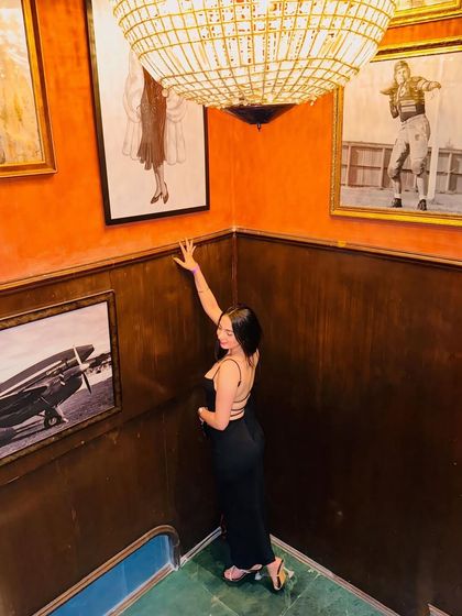 An artistic, high-angle shot on a staircase, surrounded by vintage-style art. This shows my creative approach to photoshoots.