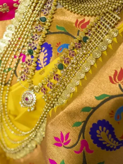 A detailed shot of the bride's traditional layered necklace against the backdrop of her vibrant Paithani saree.