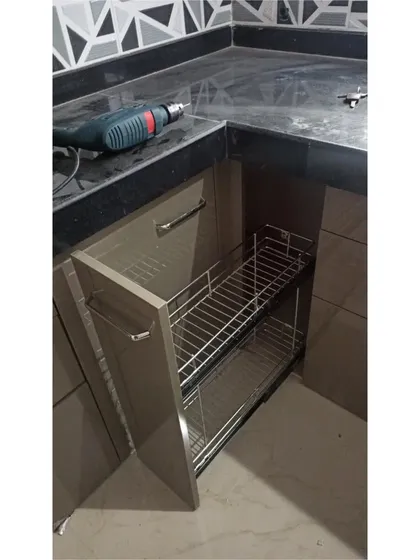 A simple yet effective bottle pull-out rack. This narrow unit makes use of small spaces, turning them into functional storage for oils, sauces, and other bottles, keeping them upright and organized.