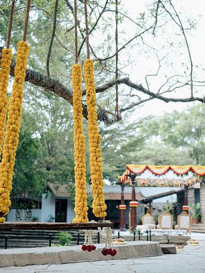 A wedding swing decorated with bright yellow marigolds, ready for a Haldi or Mehendi ceremony.