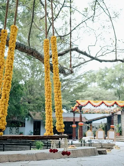 A swing decorated with bright yellow marigolds, perfect for a vibrant haldi or mehendi ceremony.