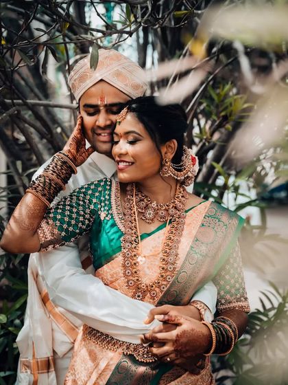 An intimate portrait of a South Indian couple, with the groom gently holding his bride, capturing their deep connection.