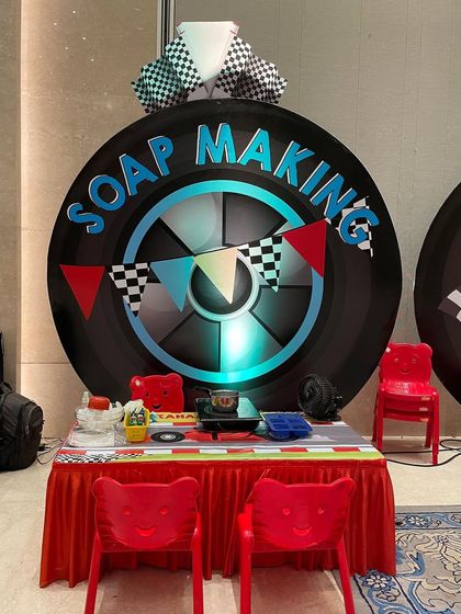 The soap making station, all set up for a race car-themed party. The bright red table and tire backdrop really set the scene for some high-speed fun.