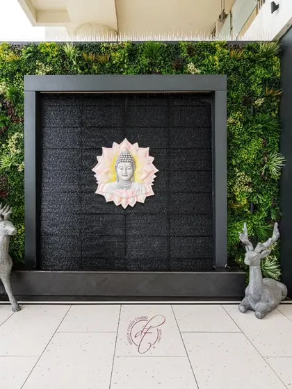 A close-up of the tranquil water wall, flanked by a vertical garden and custom wooden cabinetry for outdoor storage.