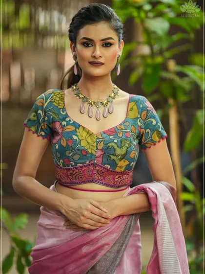 A showcase of my hand-painted artistry, this blouse features a vibrant floral Kalamkari design on a teal base. The sweetheart neckline and unique underbust paneling provide a flattering, custom fit. This piece beautifully merges traditional craft with a contemporary cut.