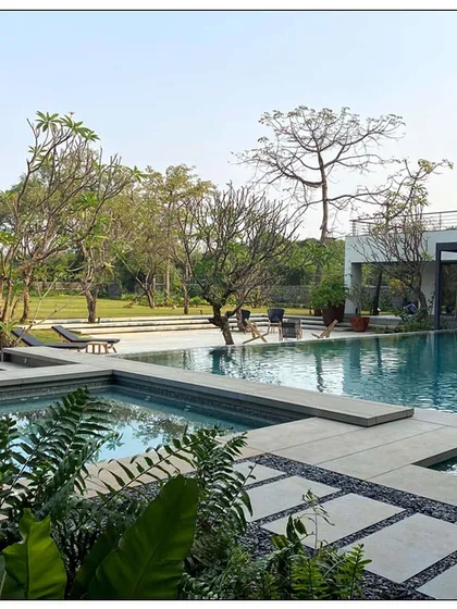 For this residential project in Alibaug, we designed the outdoor space to be an extension of the home. The expansive swimming pool is surrounded by lush landscaping and comfortable lounging areas, creating a perfect environment for leisure and entertainment that is deeply connected to its natural surroundings.