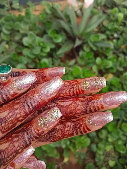 Engagement nails ready. This client chose a beautiful pink glitter base with a cluster of gold stones on the accent nail for a celebratory look.