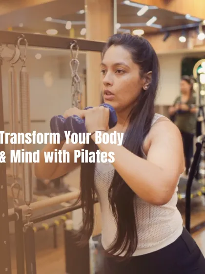 Here, a client uses dumbbells while on the Cadillac tower to add a strength training element to her Pilates workout, engaging her core to stabilize her body.